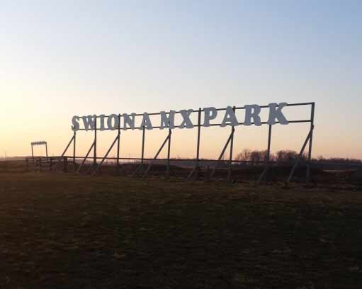 A large sign that says swonamxpark in front of the sun.